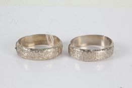 Two white metal bangles with an etched design to both, gross weight 48.2 grams (2)