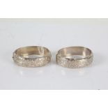 Two white metal bangles with an etched design to both, gross weight 48.2 grams (2)