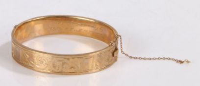 9ct gold bangle, with engraved scroll decoration to half, the interior with presentation inscription