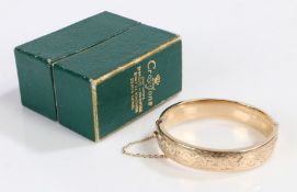 9 carat gold bangle, with engraved scroll decoration and security chain, 17.6g