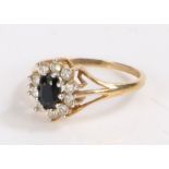 9 carat gold ring set with a central blue stone surrounded by clear paste, ring size M, 1.8g