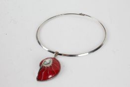 Silver necklace with a red couloured pendant shaped as a fossil