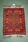 Middle eastern style rug of red and orange coulourings, with a star and circle border and four