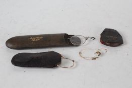 Four pairs of old spectacles, three housed in leather clad cases