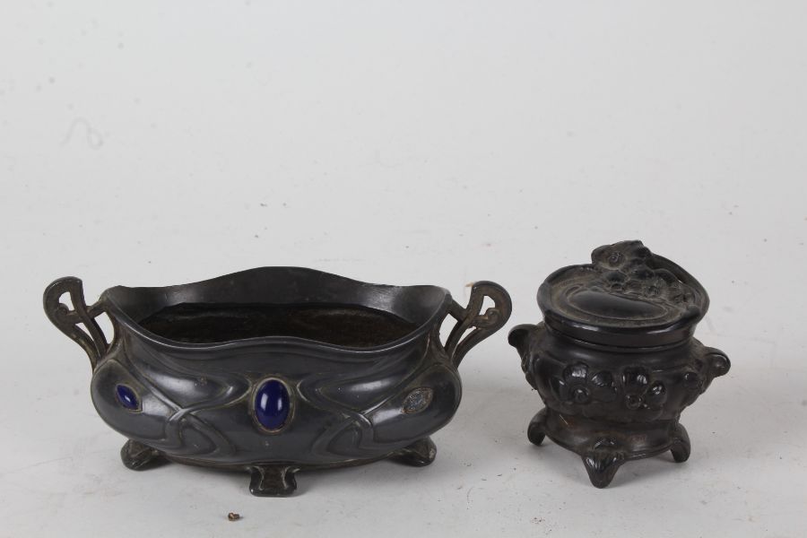 Art Nouveau pewter and enamel twin handled pot, with stylised rim and body, inset with blue enamel