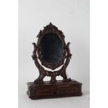 Black Forest dressing table mirror, the oval mirror with carved foliate frame on leaf carved