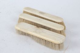 Three late 19th/early 20th century ivory mounted brushes, each monogrammed, 18cm long (3)