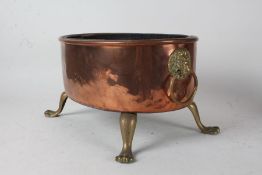 Copper and brass jardeniere, having lion mask loop handle either side, raised on four brass paw