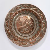 20th Century embossed copper charger, decorated to its centre with three entwined fish, framed by