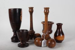 Collection of treen, to include two candlestick with cricket ball type feet, a tall lignum vitae
