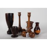 Collection of treen, to include two candlestick with cricket ball type feet, a tall lignum vitae
