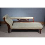 Late Victorian walnut chaise lounge, with carved stylised flowers and raised on turned legs,