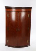 George III plum pudding mahogany bow front hanging corner cupboard. the dentil pediment above two