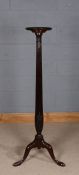 Victorian style mahogany torchere stand, the circular platform with reeded column raised on three