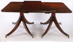 George III style mahogany twin pillar dining table, having a rounded-rectangular reeded edge top,
