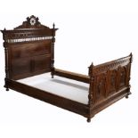 Late 19th Century carved chestnut bed, the headboard carved with flower heads above spindles and