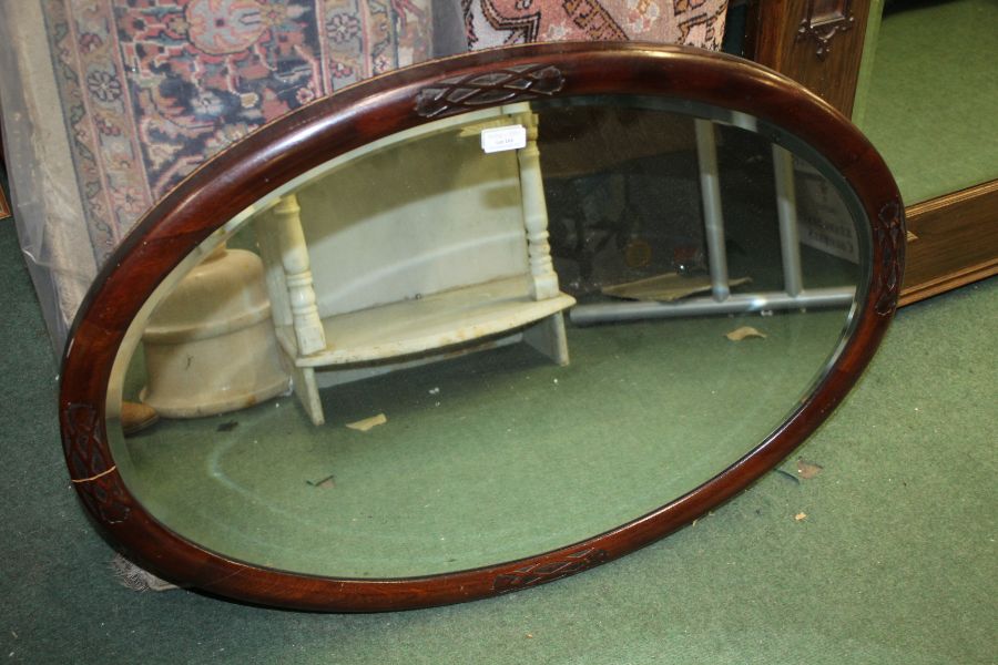 Mahogany framed oval wall mirror, with bevelled plate and blind fret carved decoration, 83cm wide,