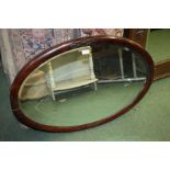 Mahogany framed oval wall mirror, with bevelled plate and blind fret carved decoration, 83cm wide,