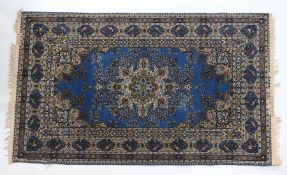 Machine made Persian design rug. The blue ground with foliate centre surrounded by a bird