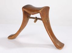 Karamojong headrest, Uganda, the shaped top above a splayed pair of supports with etched line