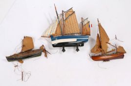 Three small wooden and paint decorated model sailing boats, the largest 22cm wide (AF) (3)