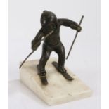 Early 20th Century continental bronze figure depicting a young boy skiing, on a sloped white