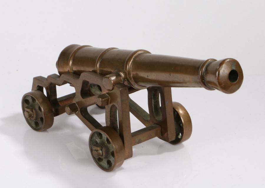 Bronze cannon, the ribbed barrel on a pierced frame with four wheels, 48cm wide