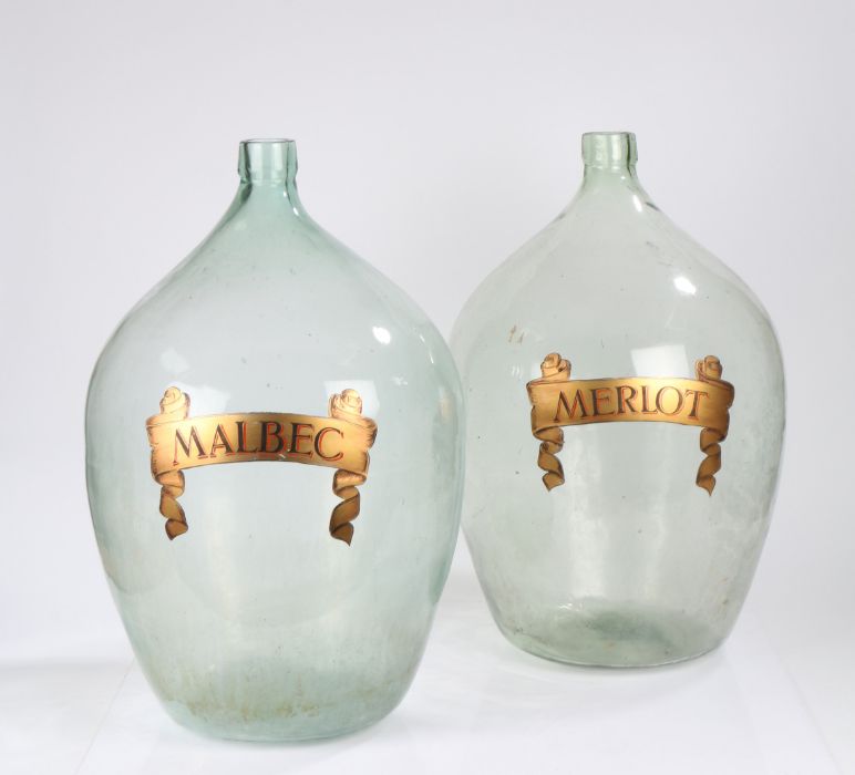 Pair of substantial glass demijohns, the bulbous bodies with gilt scrolled ribbon decoration
