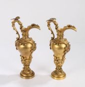 Pair of 19th Century gilt bronze ewers, with dragon capped handles to the scroll decorated spouts,