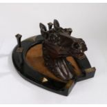Victorian carved wooden horses head, mounted to an ebonised and metal mounted horseshoe with four