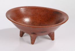 African red ware bowl, possibly Egyptian, the dished bowl raised on four tapering feet, 33.5cm