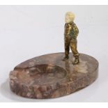 Art Deco chryselephantine figure depicting a young boy with his hands in his pockets, on a marble