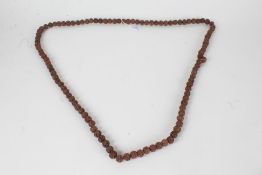 String of prayer beads, formed from dried seeds/nuts, approx. 88cm long