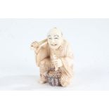 Japanese Meiji period carved ivory netsuke, in the form of street vendor holding fish, character