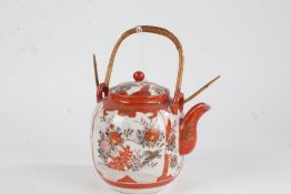 Japanese Kutani teapot, 20th century, having cane handle, painted in iron red and gilt with