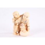 Japanese Meiji period carved ivory netsuke, in the form of two children, with coloured detailing,