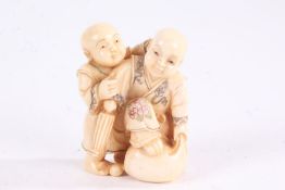 Japanese Meiji period carved ivory netsuke, in the form of two children, with coloured detailing,