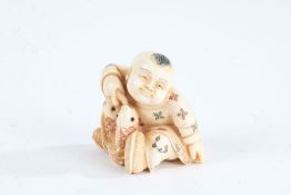Japanese Meiji period carved ivory netsuke, in the form of a boy holding fish, with coloured
