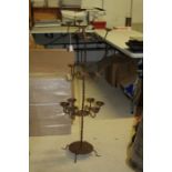 Large Asian rustic metal floor standing candle stand, having three tiers and raised on circular base