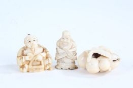 Three Japanese carved ivory netsuke, depicting a seated figure, a standing figure and a small