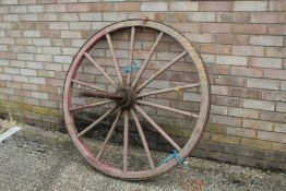 Red painted wooden and iron cart wheel, 119cm diameter approx.