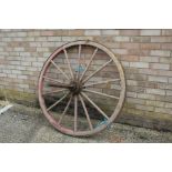 Red painted wooden and iron cart wheel, 119cm diameter approx.