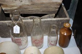 Graduated set of three glass milk bottles, with red lettering "G.W. Lord, Glebe Farm Dairy,