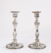 Pair of plated candlesticks, the hexagonal beaded and scroll decorated sconces above waisted