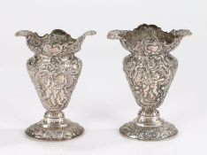 Pair of continental white metal vases, the quatrefoil form necks above bulbous tapering bodies