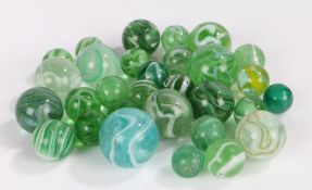 Collection of 19th century and later green glass marbles, most with opaque bands, the largest