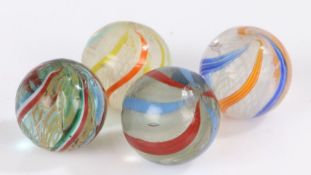 Three various Latticinio core marbles, together with a sold core swirl marble, each approx. 25mm