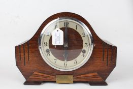 Art Deco style oak mantel clock, the arched case with engraved line decoration and brass