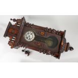 Early 20th Century mahogany cased Vienna wall clock, the pediment top flanked by finials over a