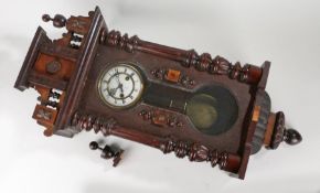 Early 20th Century mahogany cased Vienna wall clock, the pediment top flanked by finials over a